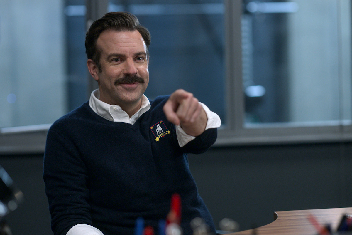 Jason Sudeikis points and smiles as Ted Lasso