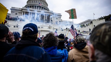 Pro-Trump supporters look on from a crowd in front of the US Capitol building during the Jan 6 insurrection.