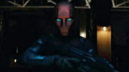 red hood in titans holding a gun and being an angsty bad boy