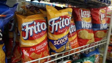 A shelf of Fritos and Lays chips in a store.