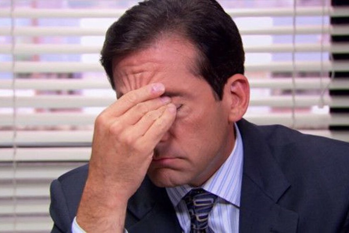 Steve Carell as Michael Scott on the Office, sits at his desk massaging his eyes.