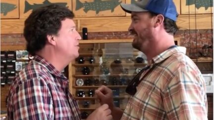 A man confronts Tucker Carlson in a fishing store.