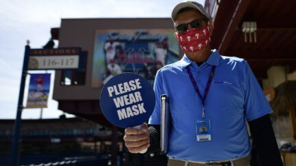 A stadium worker holds a sign reading 