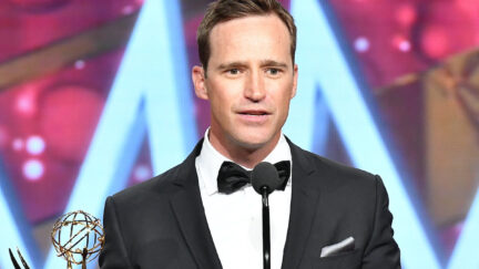 Mike Richards looks exasperated while holding an Emmy.