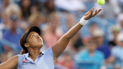Tennis star Naomi Osaka in mid-serve