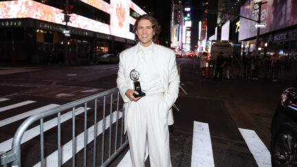 Aaron Tveit holding his Tony award outside on the streets of NYC