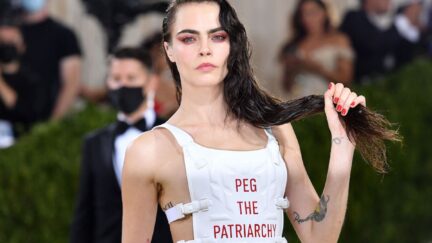 Cara Delevingne arrives for the 2021 Met Gala in a white bullet proof vest reading 