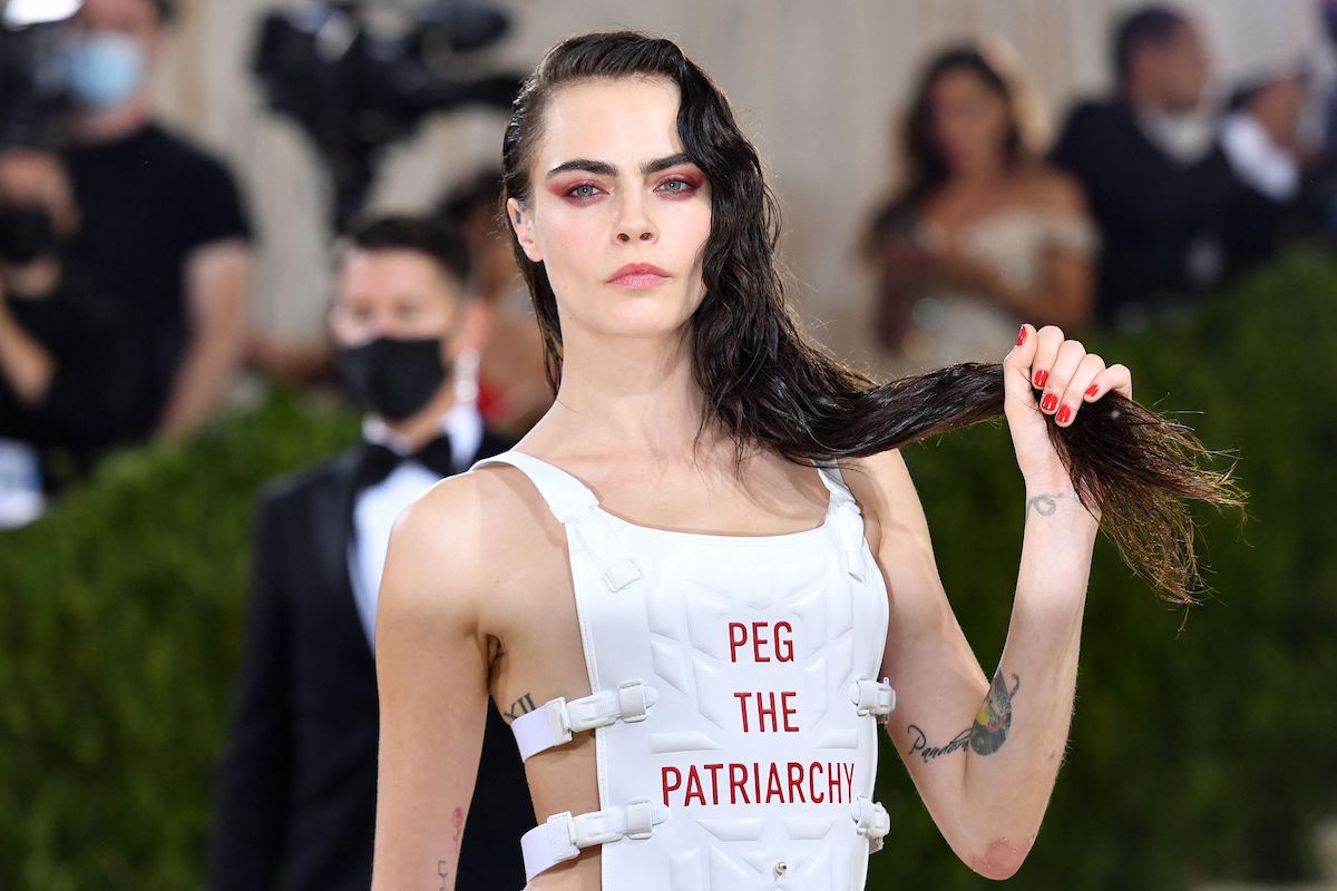 Cara Delevingne arrives for the 2021 Met Gala in a white bullet proof vest reading "peg the patriarchy"