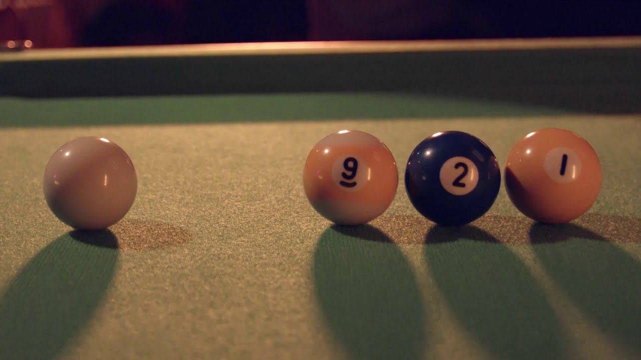 Billiard balls on a pool table, from left to right the white cue ball, 9, 2, and 1.
