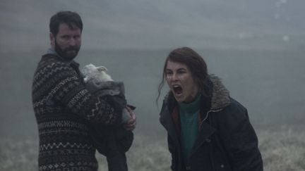 Björn Hlynur Haraldsson holding their adopted lamb-child next to Noomi Rapace, who is shouting. (Image: A24.)