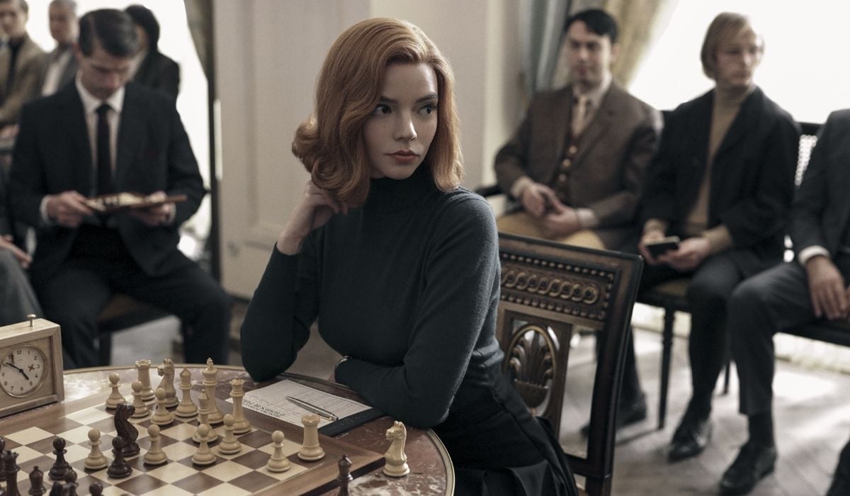 The Queen's Gambit still of her thinking at a chess set. (Image: Netflix.)