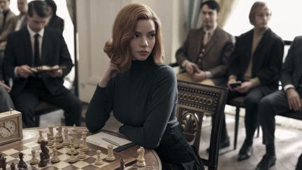 The Queen's Gambit still of her thinking at a chess set. (Image: Netflix.)