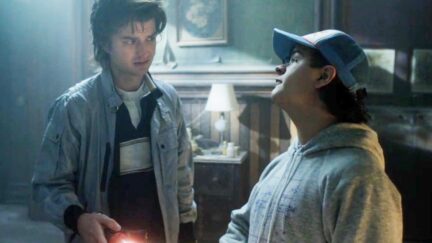 Steve Harrington and Dustin staring at each other in a haunted house in Stranger Things