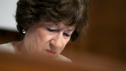 Close up of Susan Collins' face as she looks down
