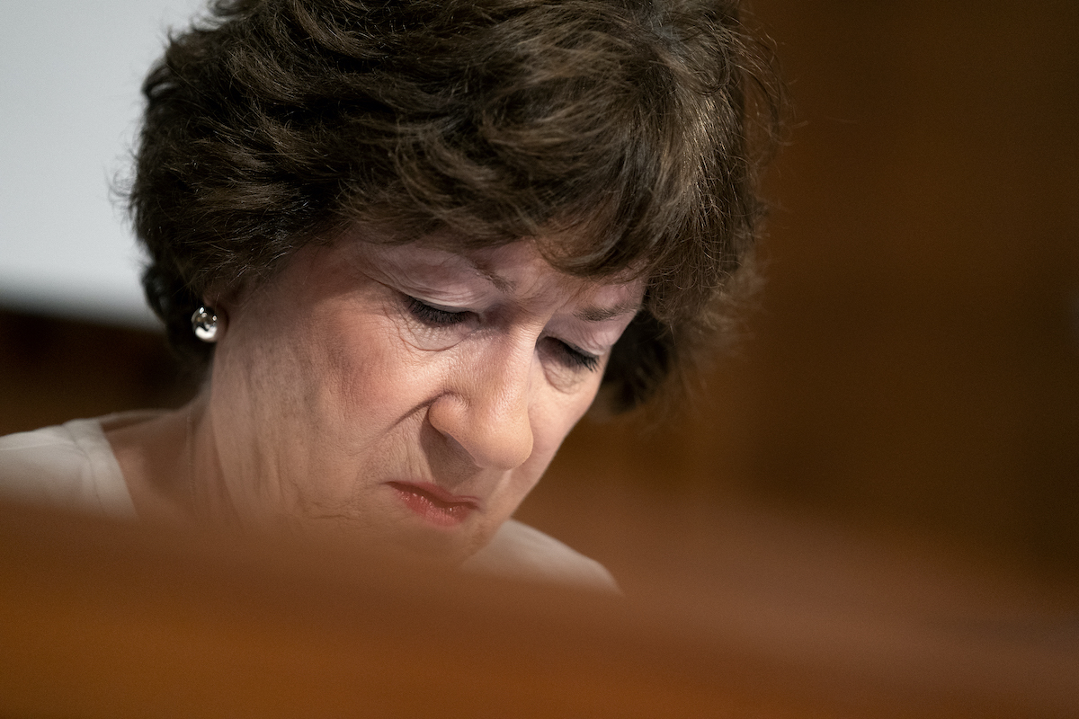 Close up of Susan Collins' face as she looks down