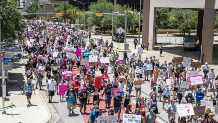 Hundreds of protesters march down a street in Texas
