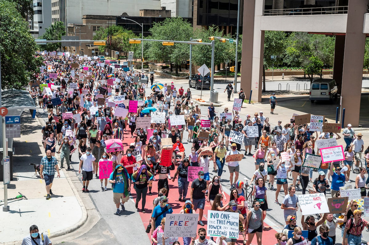 Hundreds of protesters march down a street in Texas