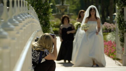 A picture of a photographer photographing a bride