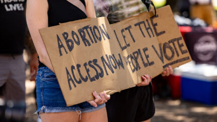 A woman carries a sign calling for access to abortion at a rally at the Texas State Capitol