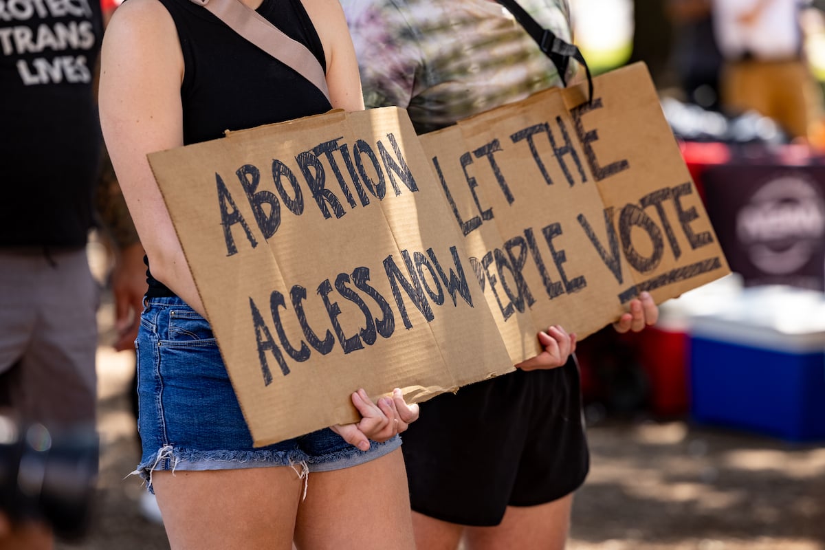 A woman carries a sign calling for access to abortion at a rally at the Texas State Capitol
