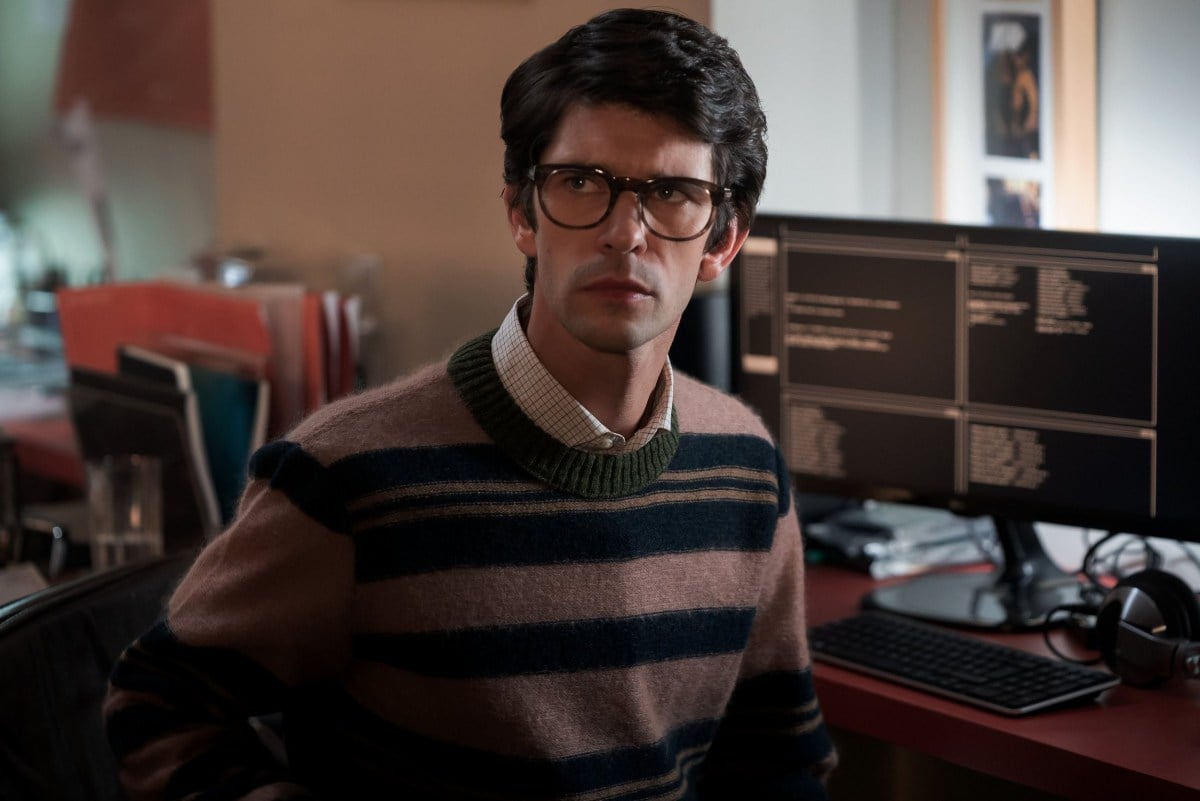 Ben Whishaw frowns in front of a computer as Q in 'No Time to Die'