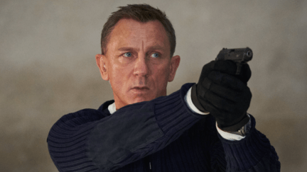Daniel Craig holds a gun with both hands as James Bond in 'No Time to Die'