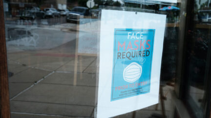 A sign in a store window reads 