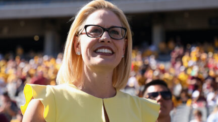 Kyrsten Sinema looks out at a crowd, smiling