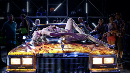 Agathe Rousselle writhes on a car in a scene from 'Titane'