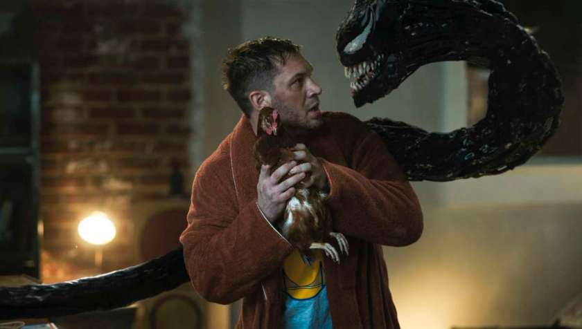 Venom yelling at Eddie while he holds a chicken in Venom: Let There Be Carnage