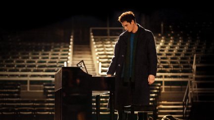 Andrew Garfield standing in front of a piano as Jonathan Larson in tick, tick...BOOM!