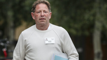 Bobby Kotick walks outside wearing a name badge.