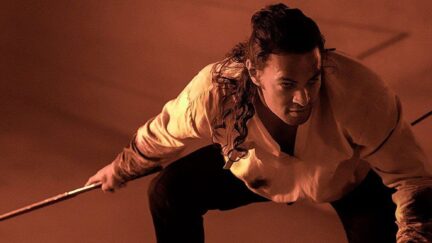 Jason Momoa bent over with a sword