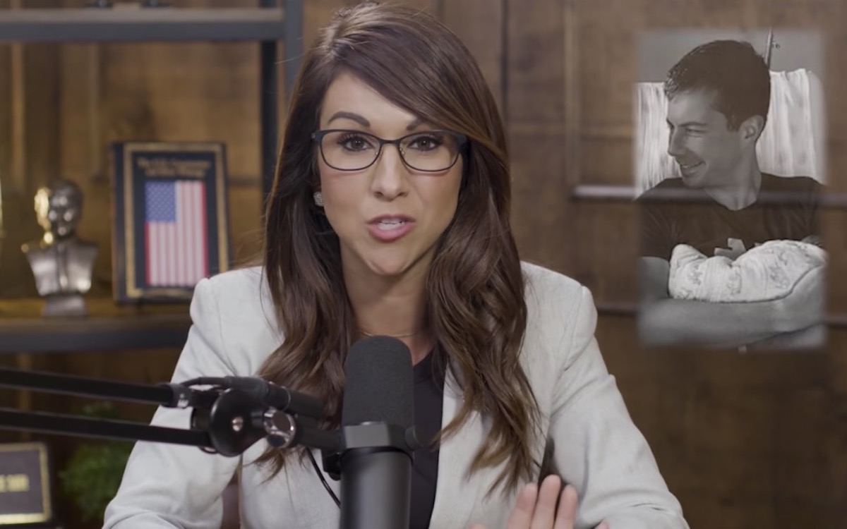 Lauren Boebert speaks into a microphone on her YouTube show next to a picture of Pete Buttigieg holding a newborn baby.