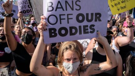 A protester at a pro-abortion rally hold a sign reading 