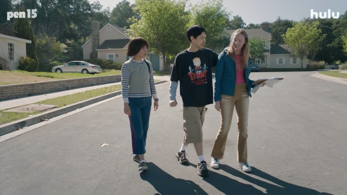 Maya and Anna walk down the street with a boy between them