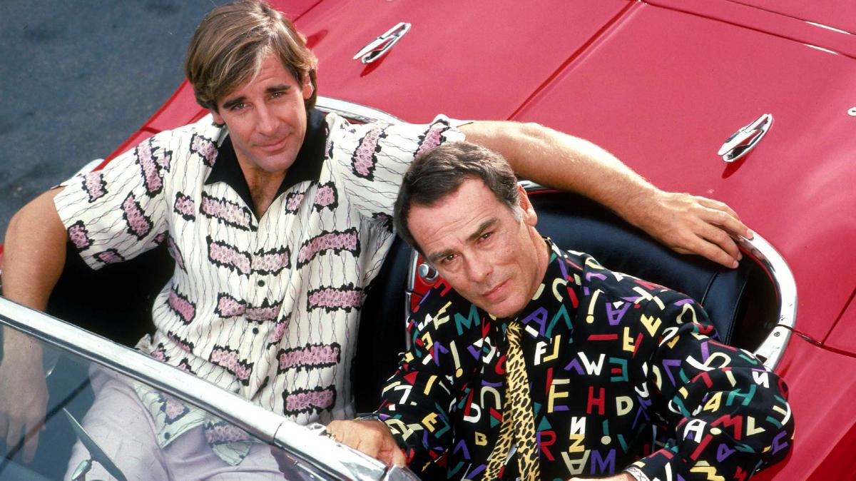 Scott Bakula and Dean Stockwell sit in a red car to promote Quantum Leap