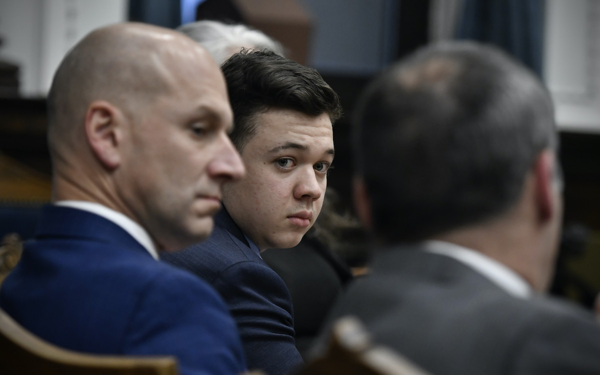 Kyle Rittenhouse, center, looks over to his attorneys during his trial