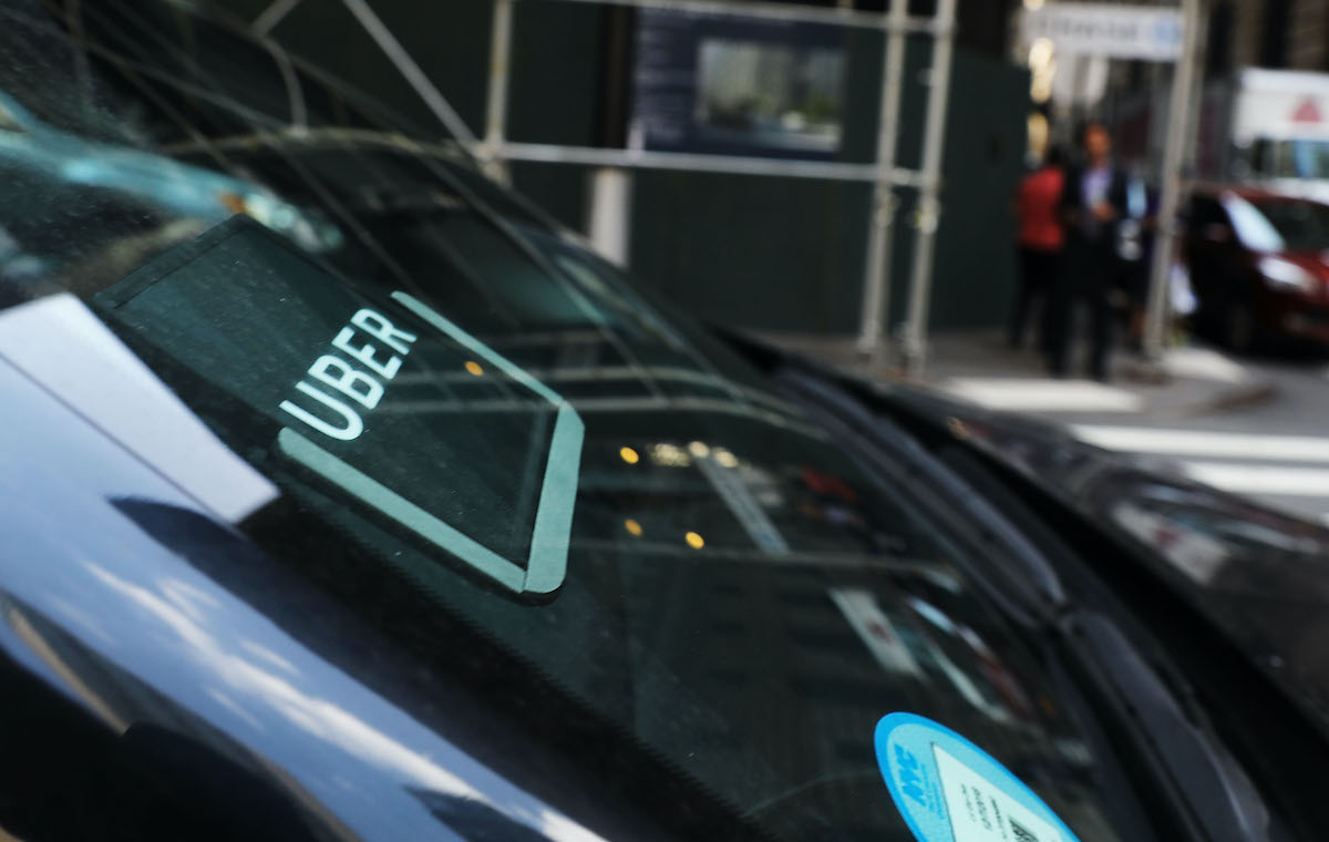 A car's windshield with an Uber sticker displayed