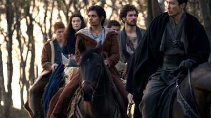 Still of Amazon's Wheel of Time cast traveling on horseback.