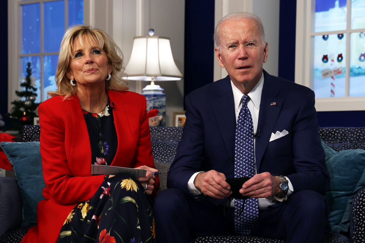 Joe and Jill Biden sit on a sofa, both looking forward, listening.