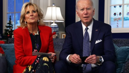 Joe and Jill Biden sit on a sofa, both looking forward, listening.