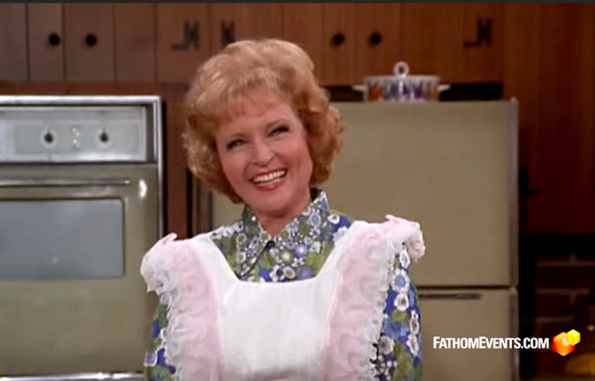 A young Betty White wears an apron and smiles at the camera during a scene from the Mary Tyler Moore Show
