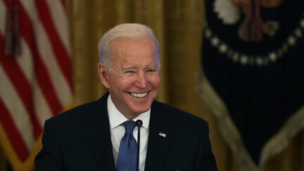 Joe Biden grins during a meeting.
