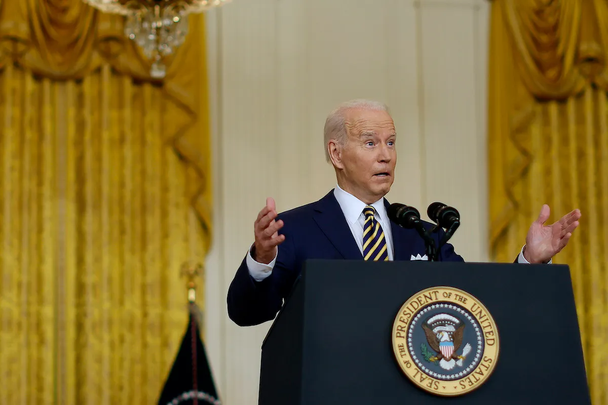 Joe Biden gestures and looks surprised while giving a speech from a podium.