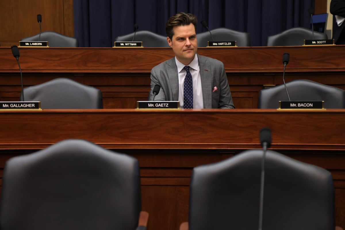 Matt Gaetz sits in the House chamber surrounded by empty desks.