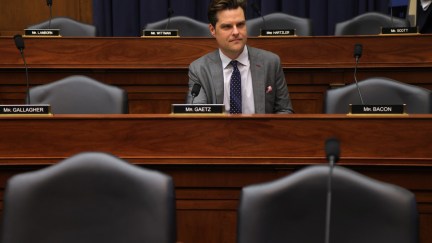 Matt Gaetz sits in the House chamber surrounded by empty desks.