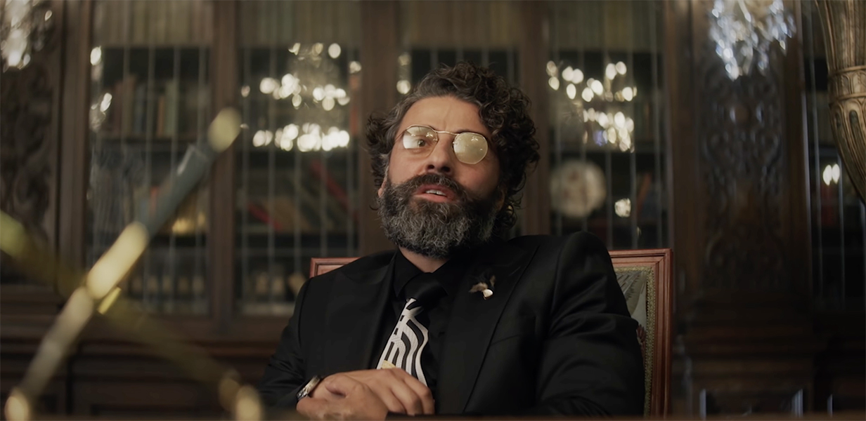 Oscar Isaac with a weird vibe and glasses in the Big Gold Brick trailer