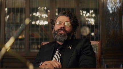Oscar Isaac with a weird vibe and glasses in the Big Gold Brick trailer