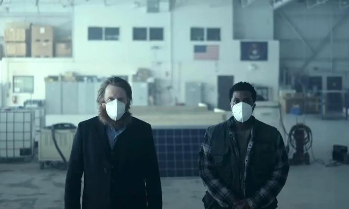 Two men wearing masks stand in the Severn Michigan airport in HBO's 'Station Eleven'